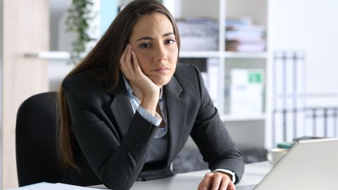 Bored,Executive,Woman,With,Laptop,Looking,At,Camera,Sitting,On
