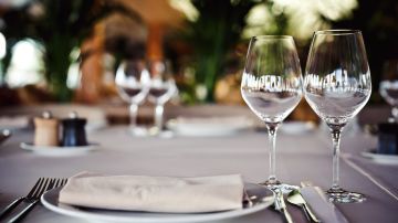 Plato y copas en mesa de restaurante