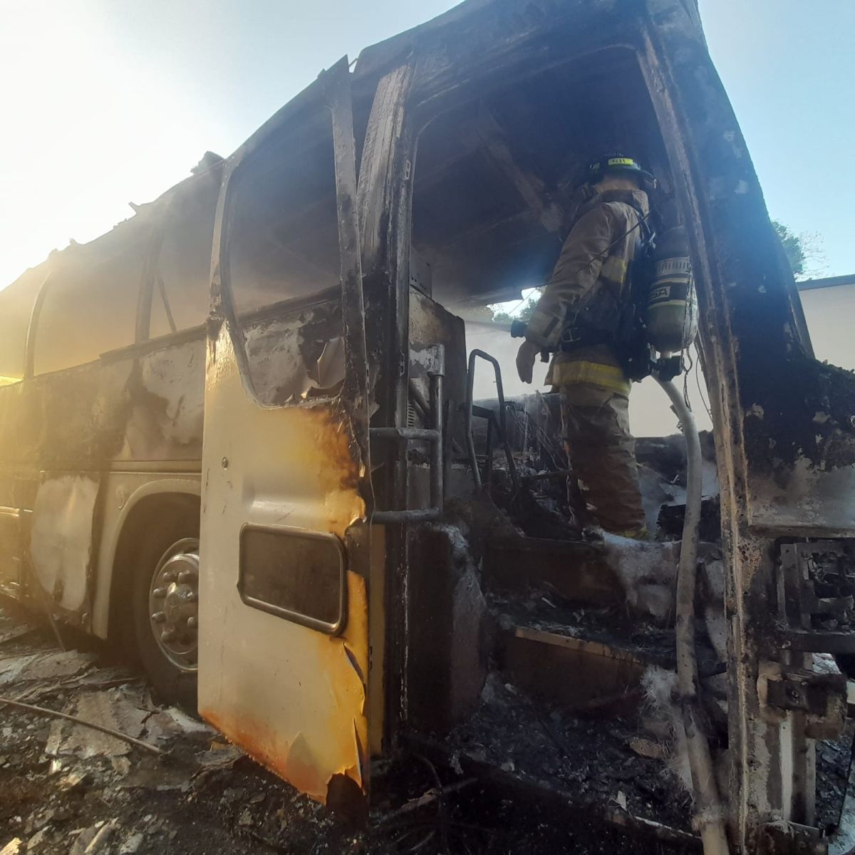 Bomberos en Panamá mientras trabajan para apagar un incendio en un bus que trasladaba a 57 migrantes en la carretera panamericana.  