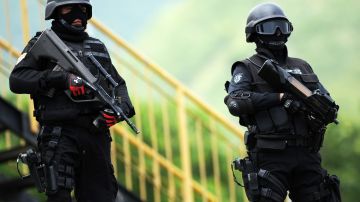 Anti-drug squad members stand guard duri