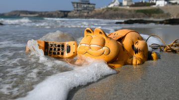 Un teléfono de colección del gato Garfield en una playa de Bretaña, Francia.