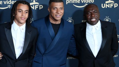 Ethan Mbappé (I), Kylian Mbappé (C) y el padre Wilfried Mbappe, posan ante las cámaras el 15 de mayo de 2022 en París.