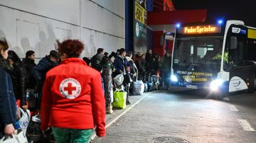 Ucranianos se forman para tomar un autobús con rumbo a Polonia.