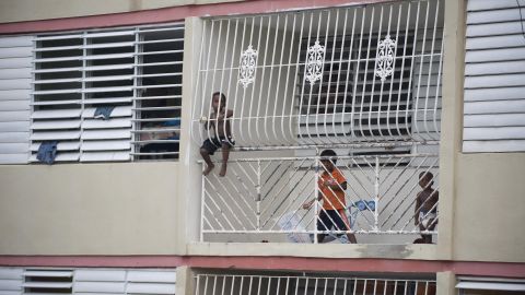 Children watch from a window as the camp