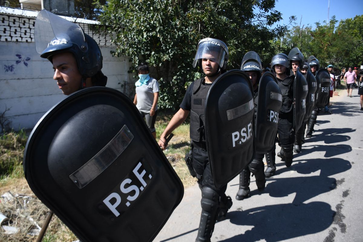 La policía llega al sitio donde la gente saquea y destruye la casa de un presunto narcotraficante en Rosario, provincia de Santa Fe, Argentina.