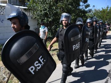 La policía llega al sitio donde la gente saquea y destruye la casa de un presunto narcotraficante en Rosario, provincia de Santa Fe, Argentina