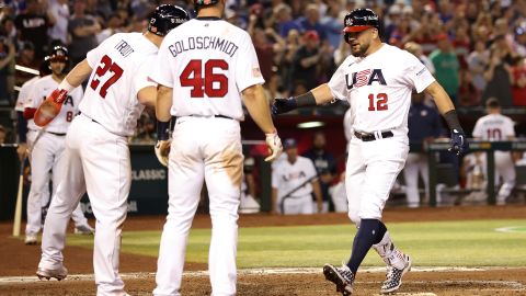 Kyle Schwarber (R) es felicitado por Paul Goldschmidt y Mike Trout luego de conectar jonrón ante Gran Bretaña.