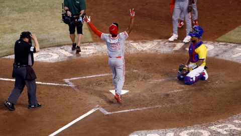 Otto López pisa el plato luego de disparar un cuadrangular ante la mirada del catcher colombiano Elías Díaz.