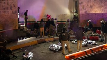 Rescatistas trabajan para sacar a los heridos y los cadáveres de las víctimas fuera de las instalaciones migratorias en Ciudad Juárez.