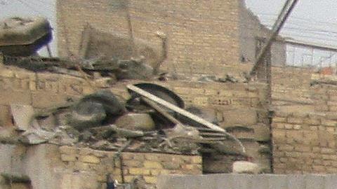 An Iraqi youth fills a pan with drinking
