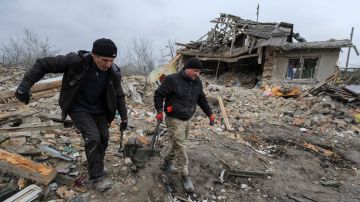 Un grupo desalojan una casa después de que dos cohetes impactaran en el distrito de Zolochiv.