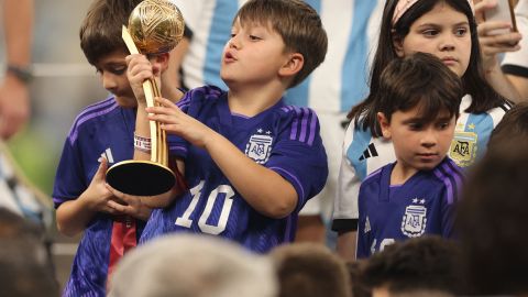 Mateo Messi sostiene el premio que conquistó su padre Lionel como mejor jugador del Mundial Qatar 2022.