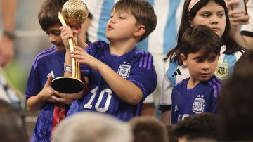 Mateo Messi sostiene el premio que conquistó su padre Lionel como mejor jugador del Mundial Qatar 2022.