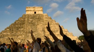 Los visitantes levantan la mano durante los festejos por el fin del ciclo maya conocido.