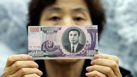 Una activista contra Corea del Norte muestra un billete de 5,000 wons norcoreanos.