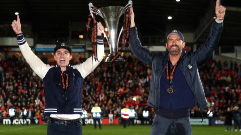 Rob McElhenney (I) y Ryan Reynolds (D) con el trofeo de campeones.