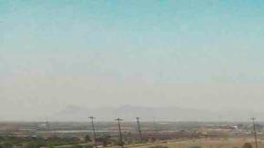 Fotografía aérea muestra a cientos de migrantes mientras esperan por papeles junto al muro fronterizo en El Paso, Texas