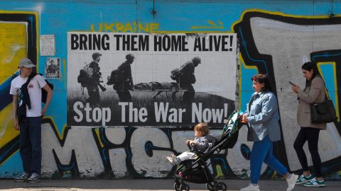 Un grupo de personas pasa frente a un cartel contra la guerra en el centro de Kiev.