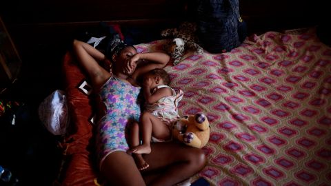 Una migrante venezolana junto a su hijo descansan en un albergue temporal tras cruzar la selva del Darién.