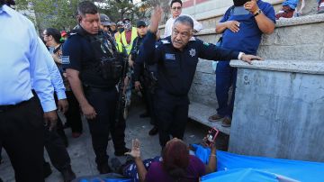 Policías mexicanos desalojan a migrantes varados en calles de la fronteriza Ciudad Juárez.