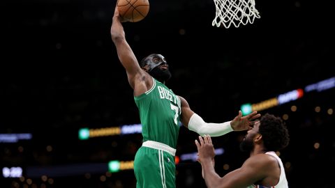 Jaylen Brown (L) clava la pelota ante la mirada de Joel Embiid (R).