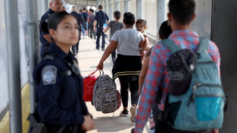 Inmigrantes cruzan el Puente Internacional Matamoros-Brownsville hacia Estados Unidos luego de obtener una cita para ingresar legalmente al país.