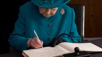 La reina Isabel II escribiendo una carta.