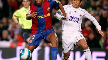 BARCELONA, SPAIN - MARCH 10:  Ronaldinho disputa un balón con Michel Salgado en un Clásico español durante el año 2007