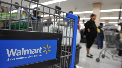 Shoppers wait in line to pay for their p