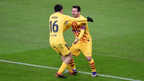 Pedri González (I) se abraza con Leo Messi (D).