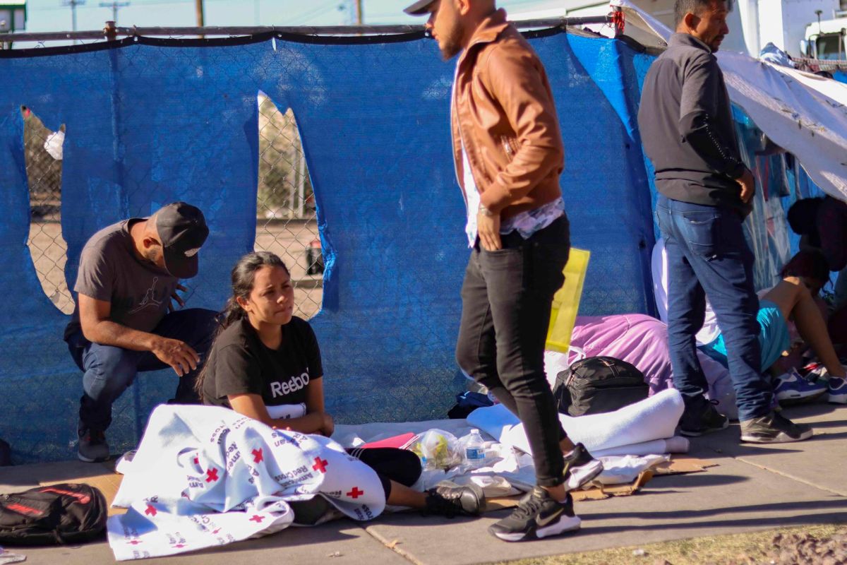 Una inmigrante se tapa con una manta de la Cruz Roja mientras espera en el suelo junto a otros inmigrantes el lunes 8 de mayo en los alrededores de la Iglesia de Sagrado Corazón de Jesús en la ciudad de El Paso, Texas.