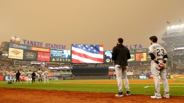 Jugadores de New York Yankees y Chicago White Sox ven la nube de humo que se posa sobre el Yankee Stadium.