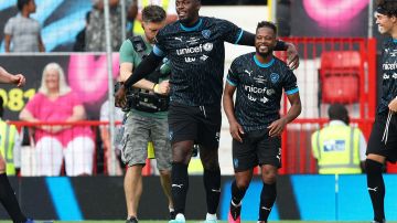 Usain Bolt (L) celebra su gol junto al exfutbolista Patrice Evra (R).
