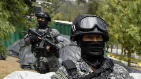 Un grupo de agentes de la Policía Nacional de Ecuador custodia varias bolsas con bloques de cocaína para ser destruidos.