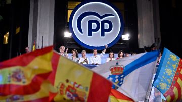 El líder y candidato del conservador Partido Popular, Alberto Núñez Feijoo, alza el puño mientras se dirige a sus seguidores desde un balcón de la sede del PP en Madrid tras las elecciones generales de España.