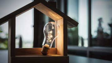 Light,Bulb,With,Wood,House,On,The,Table,,A,Symbol