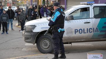 Un oficial de policía de la provincia de Buenos Aires custodia un supermercado 'Dia' después de que fue saqueado.