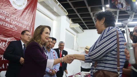 Yasmín Esquivel, saluda a una asistente a una charla sobre los derechos de los migrantes.