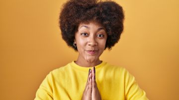 Young,African,American,Woman,Standing,Over,Yellow,Background,Praying,With