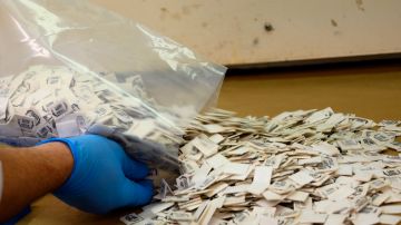 Un químico de la Administración de Control de Drogas (DEA) vierte paquetes de fentanilo confirmado en un mostrador para realizar pruebas en el Laboratorio Regional Noreste de la DEA en Nueva York.