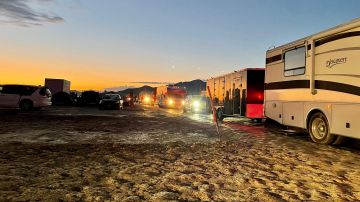 Los vehículos hacen fila para abandonar el sitio del Festival Burning Man anual después de que las fuertes lluvias convirtieran el sitio en el desierto Black Rock de Nevada en un pozo de barro.