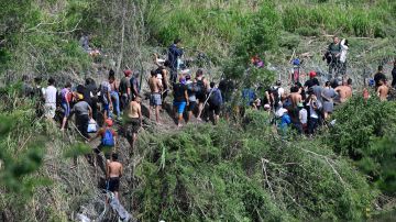 Migrantes derriban a la Guardia Nacional y el cerco de púas en la frontera.
