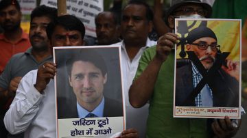 Miembros de la organización Frente Hindú Unido sostienen pancartas que representan al Primer Ministro de Canadá, Justin Trudeau.