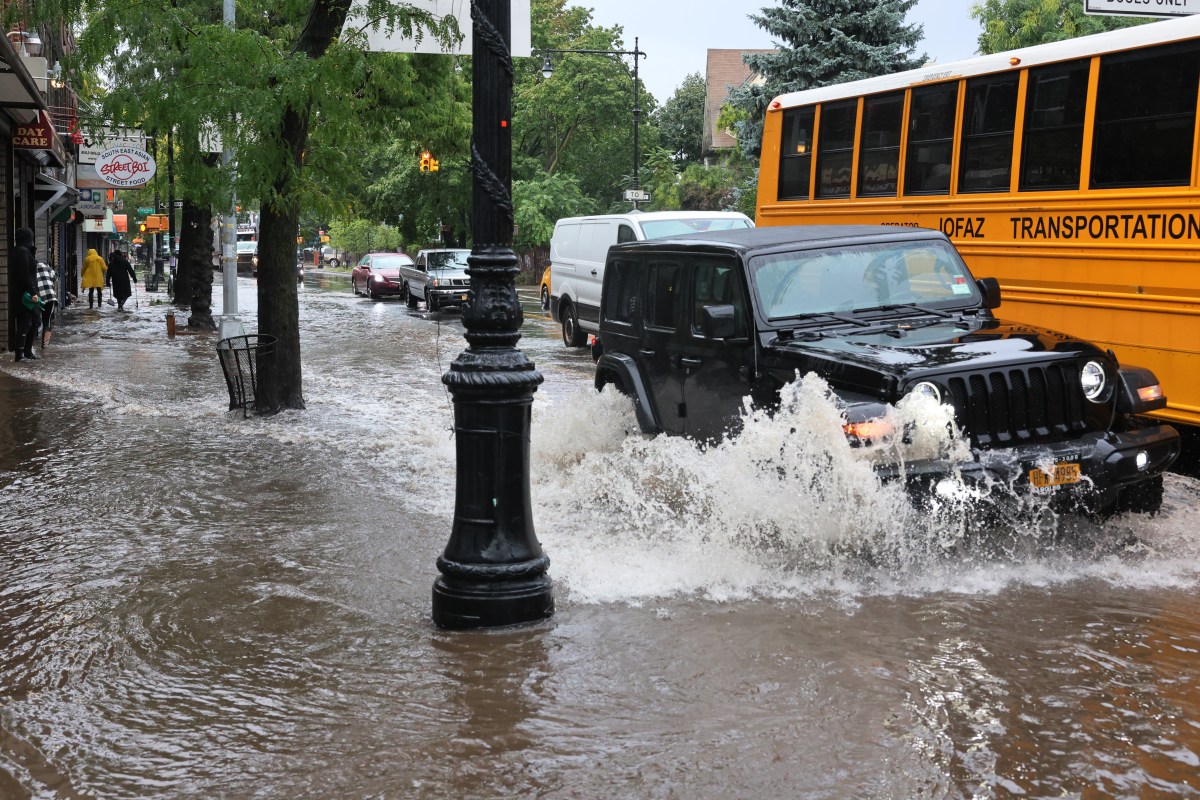 Los automóviles circulan por una calle inundada en Church Avenue en medio de una tormenta costera en Brooklyn.