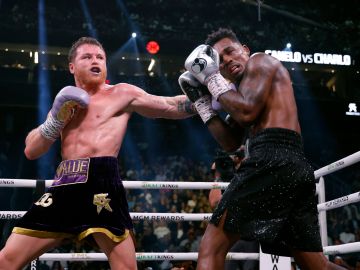 Canelo Álvarez (L) impacta un golpe en el rostro de Jermell Charlo (R).
