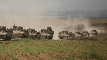 Un vehículo blindado de transporte de personal israelí se mueve en formación cerca de la frontera con Gaza.