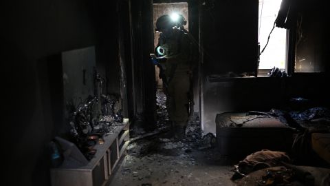 Soldados israelíes inspeccionan el interior de una casa quemada cerca de la frontera con la Franja de Gaza.