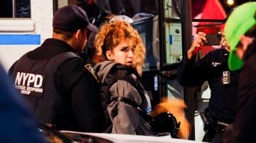 Una mujer es arrestada por agentes de policía después de que manifestantes se enfrentaran con miembros del NYPD.