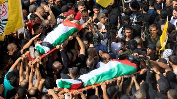 Los dolientes cargan los cuerpos de dos hombres palestinos durante los ataques israelíes.