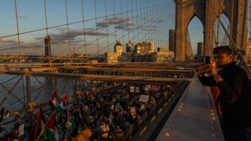 La gente cruza el Puente de Brooklyn mientras participa en una protesta en apoyo del pueblo palestino.